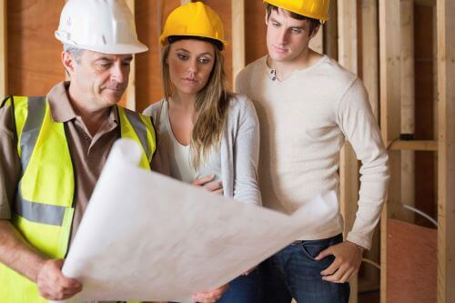 Builder helping clients with house plans